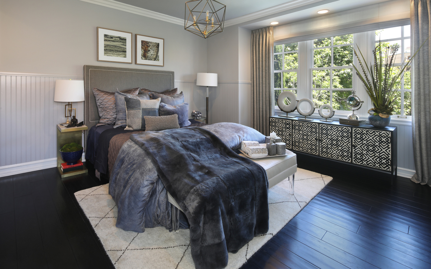 Большая кровать с мягким серым покрывалом в спальне 