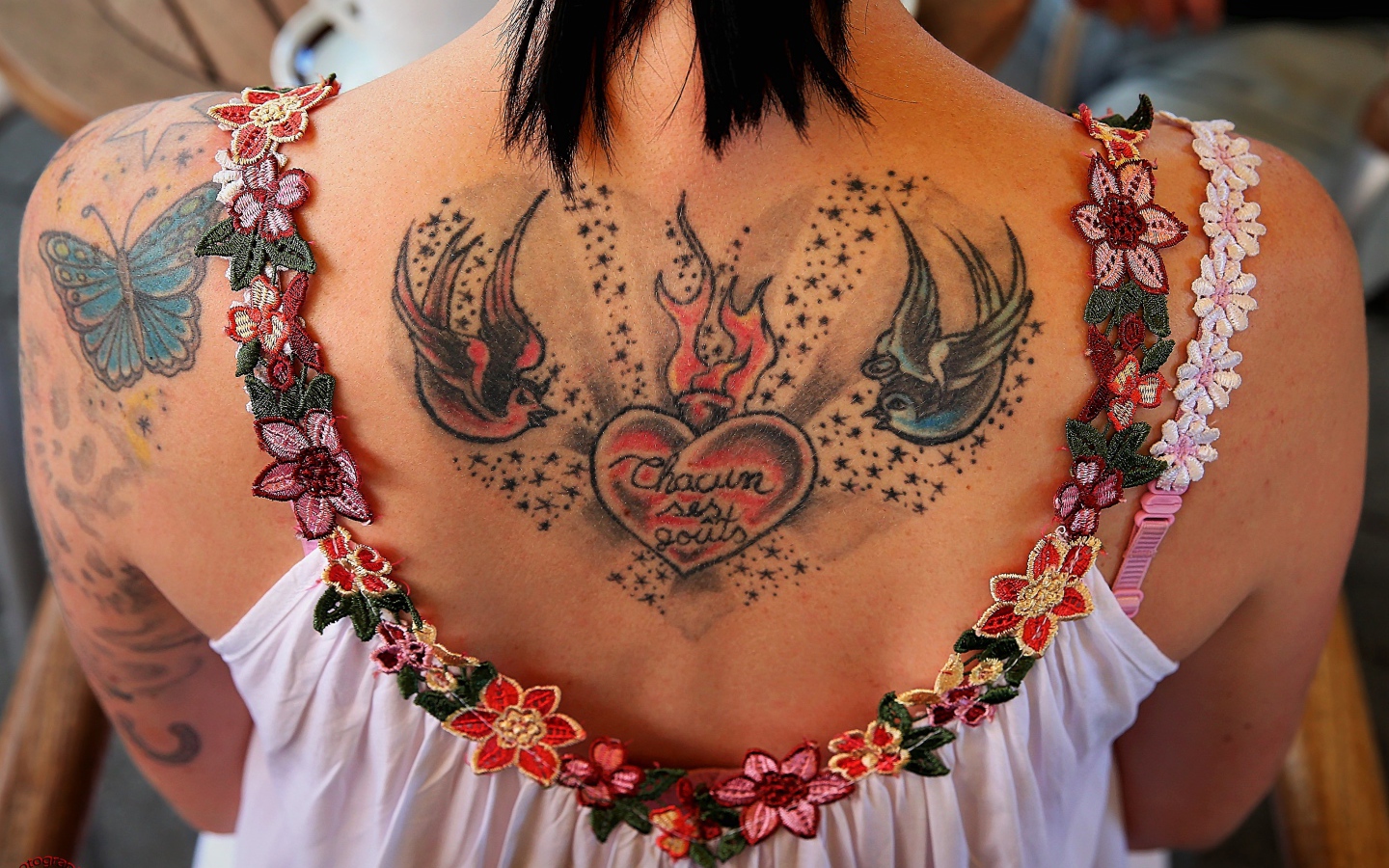 Large tattoo on the back of a girl in a white dress