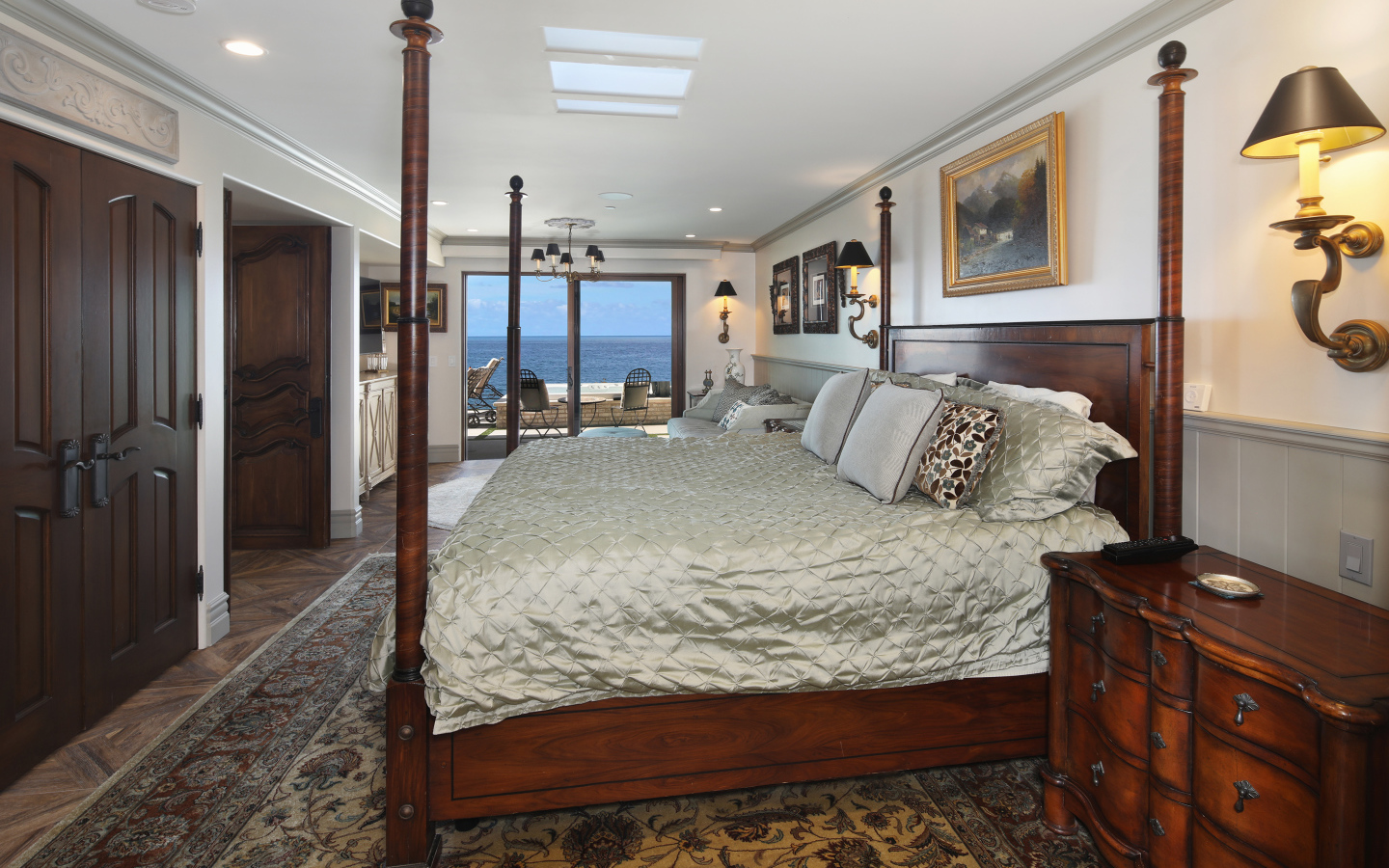 Большая деревянная кровать в спальне с видом на море 