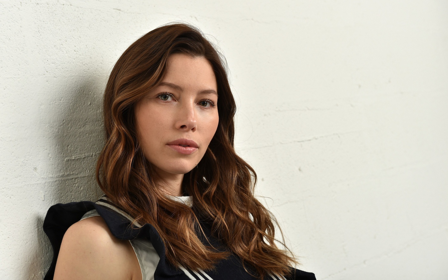 Грустная актриса Джессика Бил сидит у стены