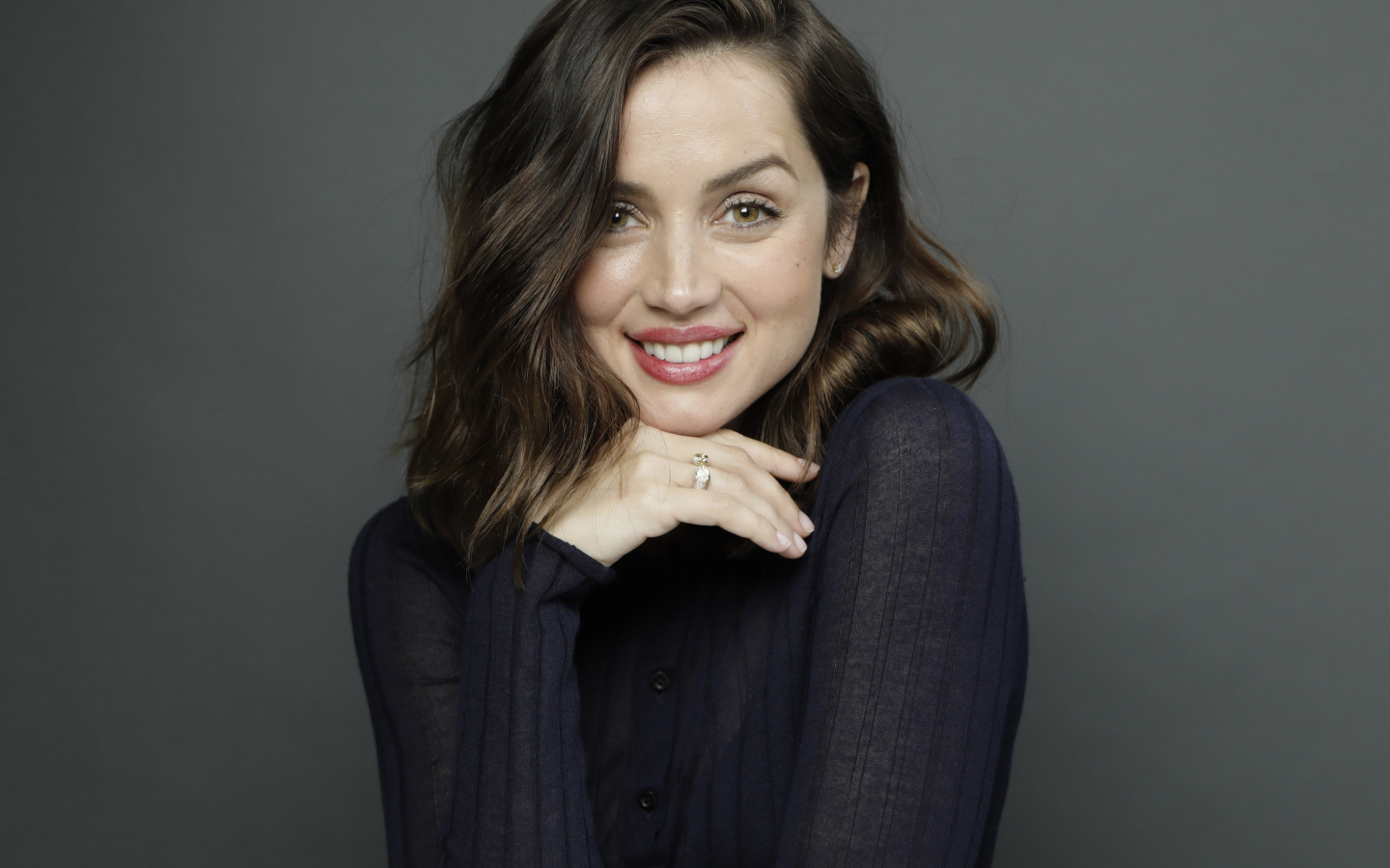 Улыбающаяся актриса Ана де Армас на сером фоне