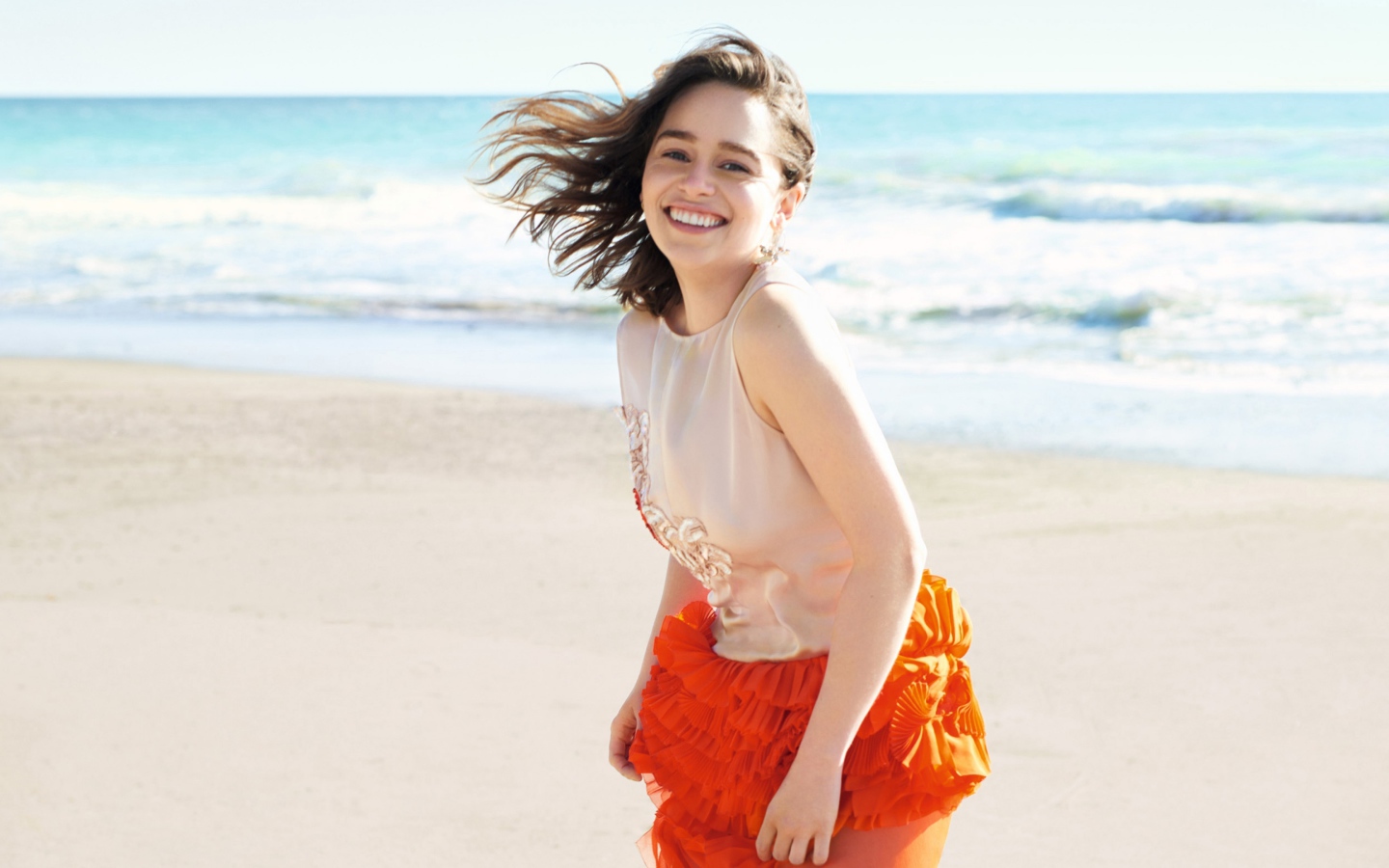 Улыбающаяся девушка, актриса Эмилия Кларк на фоне моря