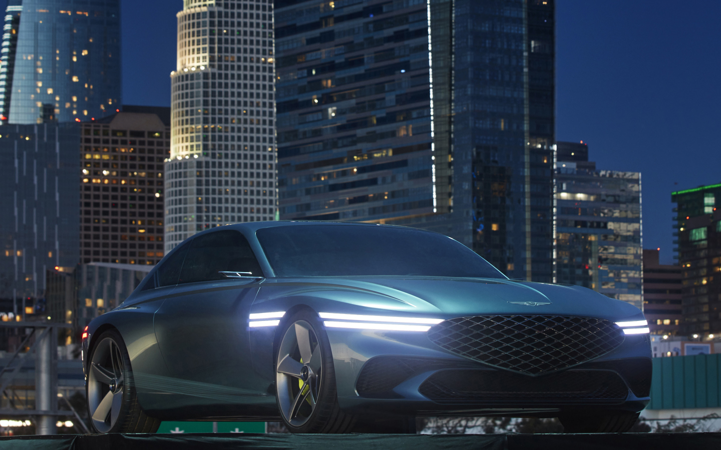 Новый автомобиль Genesis X Concept 2021  года на фоне небоскребов