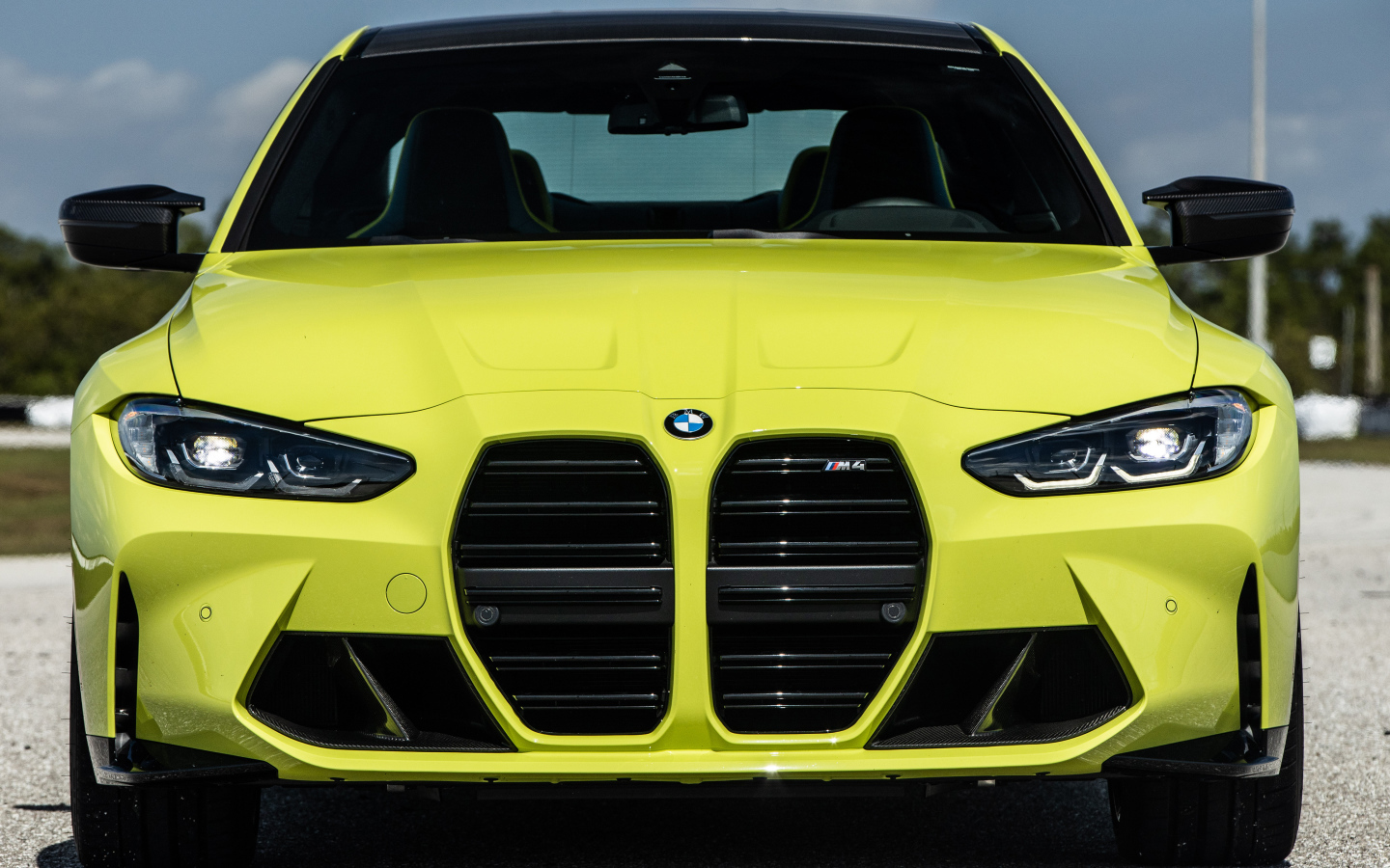 Желтый автомобиль  BMW M4 Coupé 2021 года вид спереди