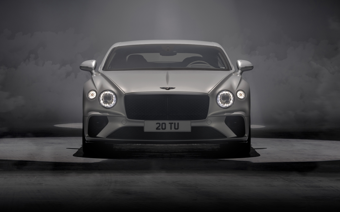 Серебристый автомобиль Bentley Continental GT Speed 2021 года на сером фоне