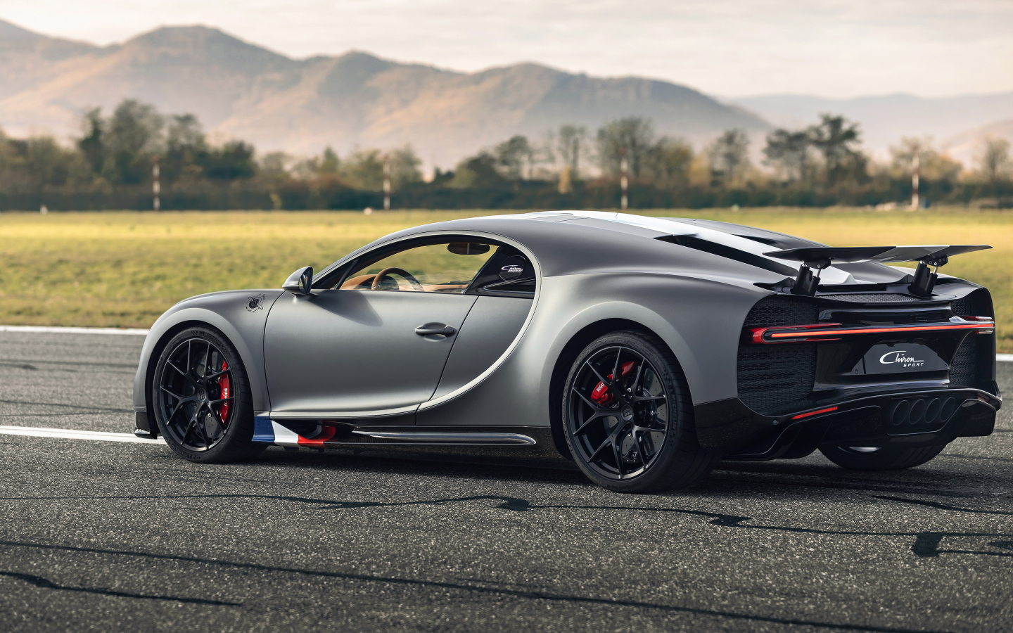 Серебристый спортивный автомобиль Bugatti Chiron  вид сзади