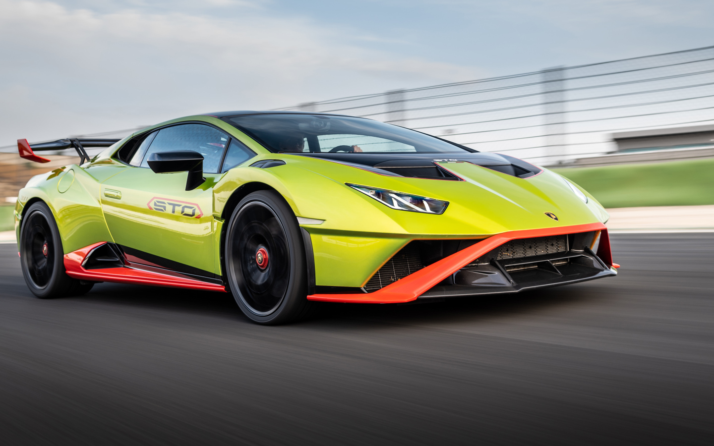 Зеленый автомобиль Lamborghini Huracán STO 2021 года на высокой скорости 