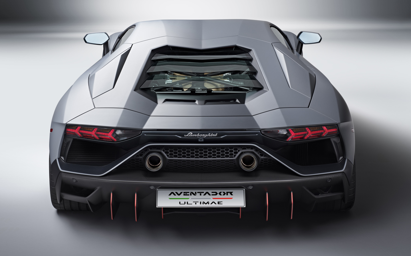 Вид сзади на автомобиль Lamborghini Aventador LP 780-4 Ultimate 2021 года на сером фоне