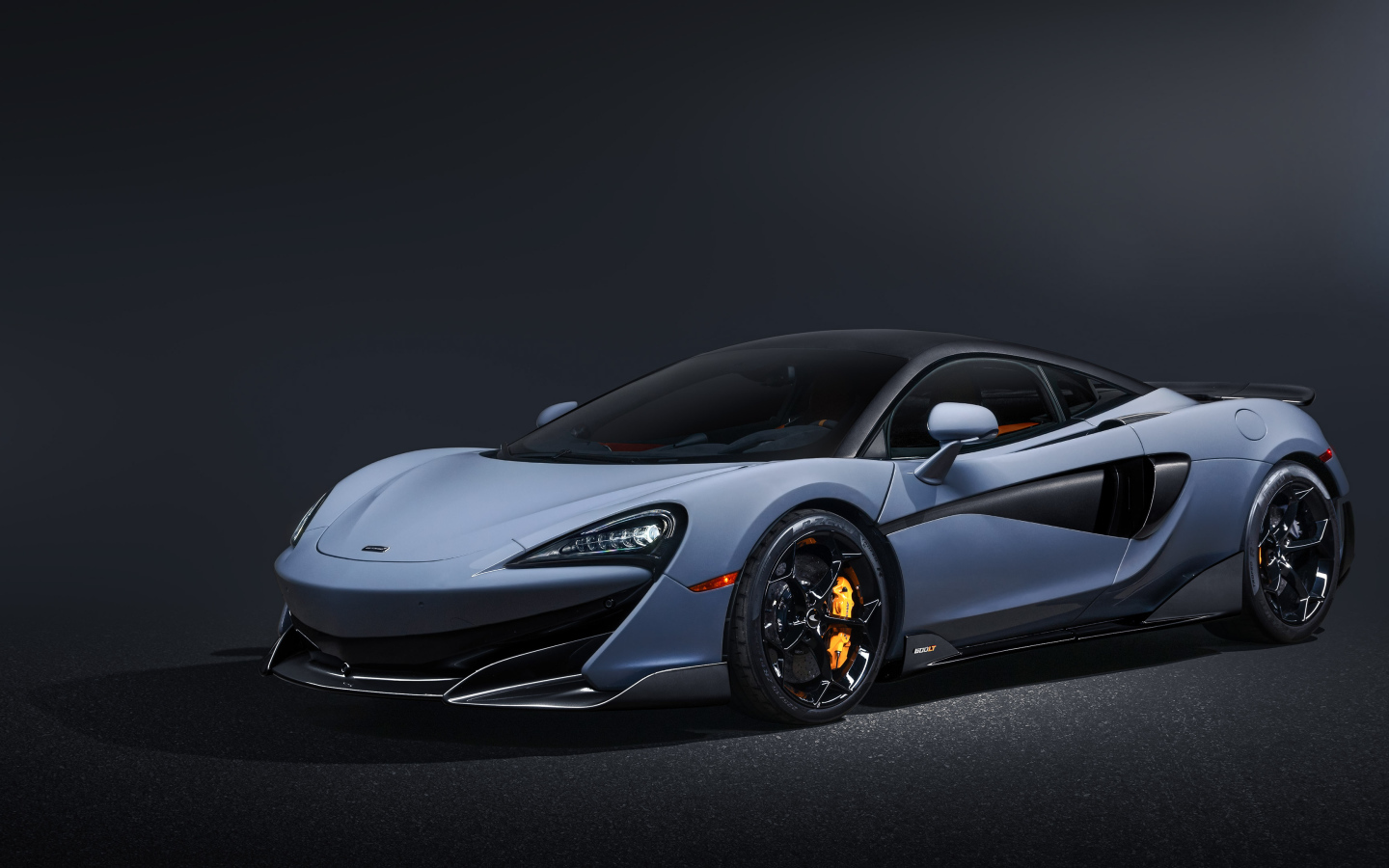 Быстрый автомобиль McLaren 600LT на черном фоне