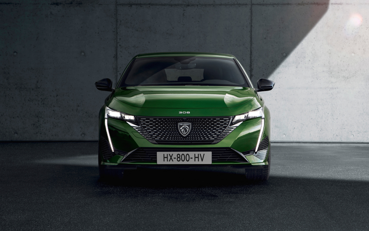 Автомобиль Peugeot 308, 2021 года вид спереди на фоне стены