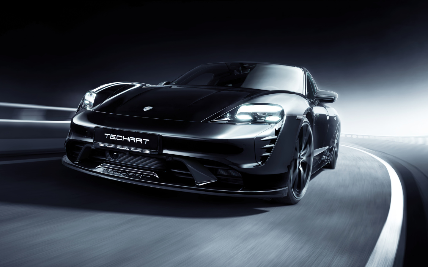 Черный Porsche Taycan Aerokit 2021 года на трассе