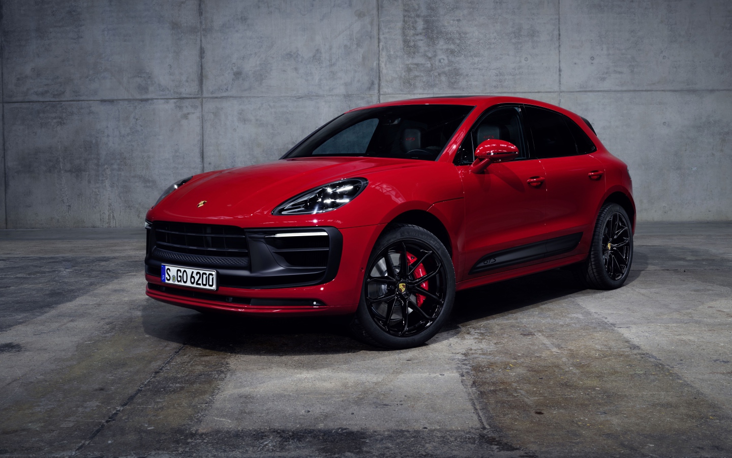 Красный автомобиль Porsche Macan GTS 2021 года на сером фоне