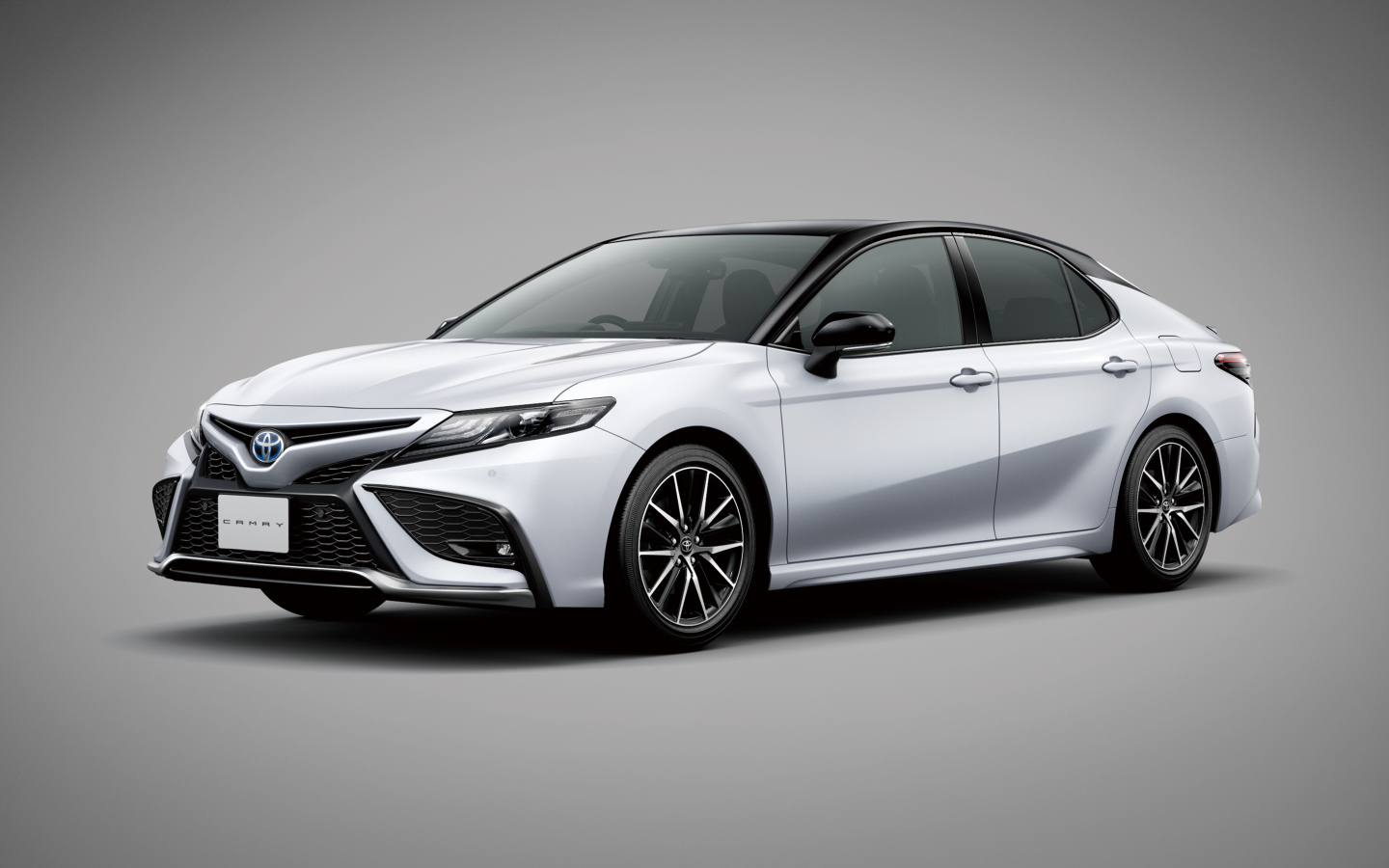 Автомобиль Toyota Camry 2021 года на сером фоне