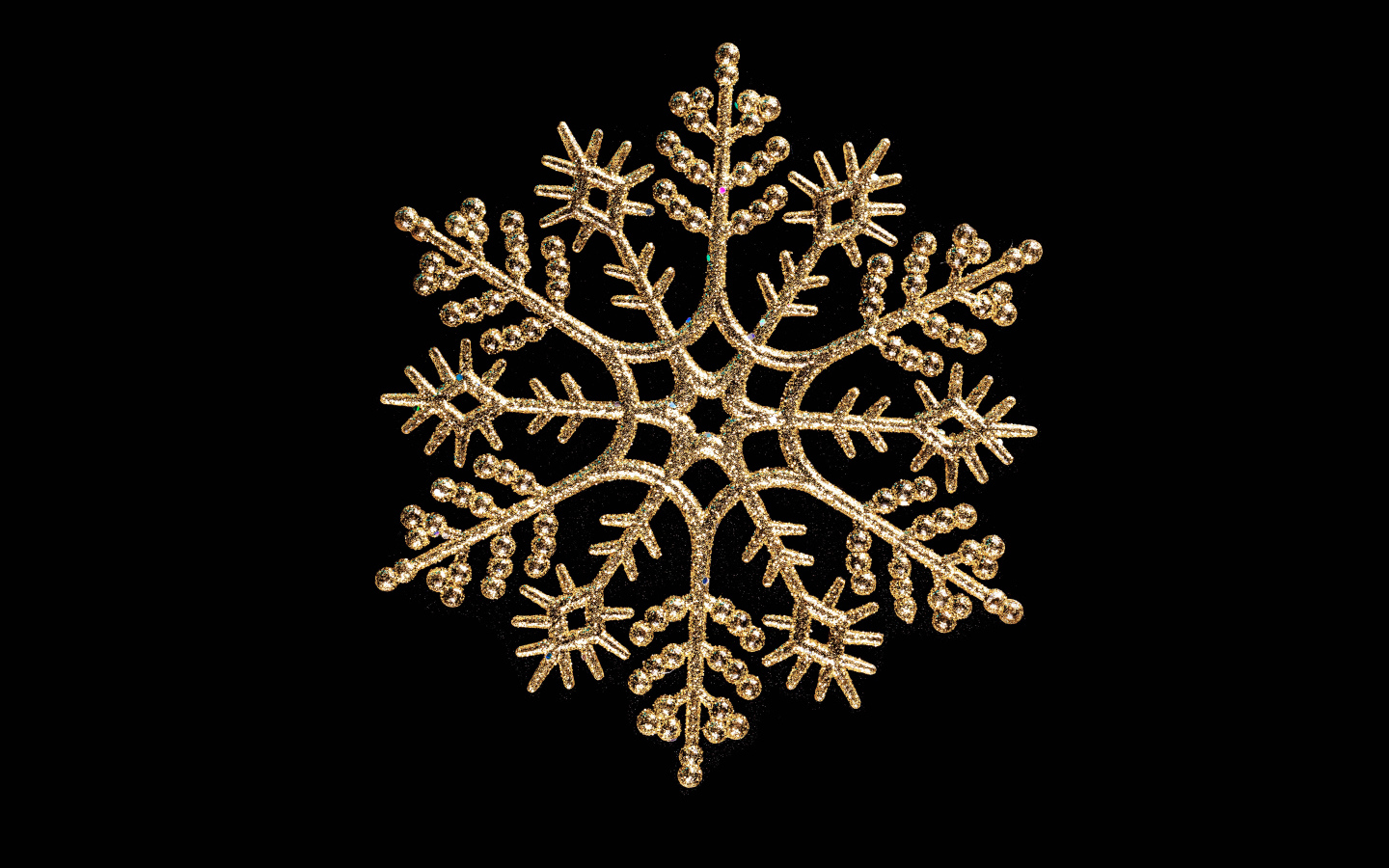 Красивая золотистая снежинка на черном фоне