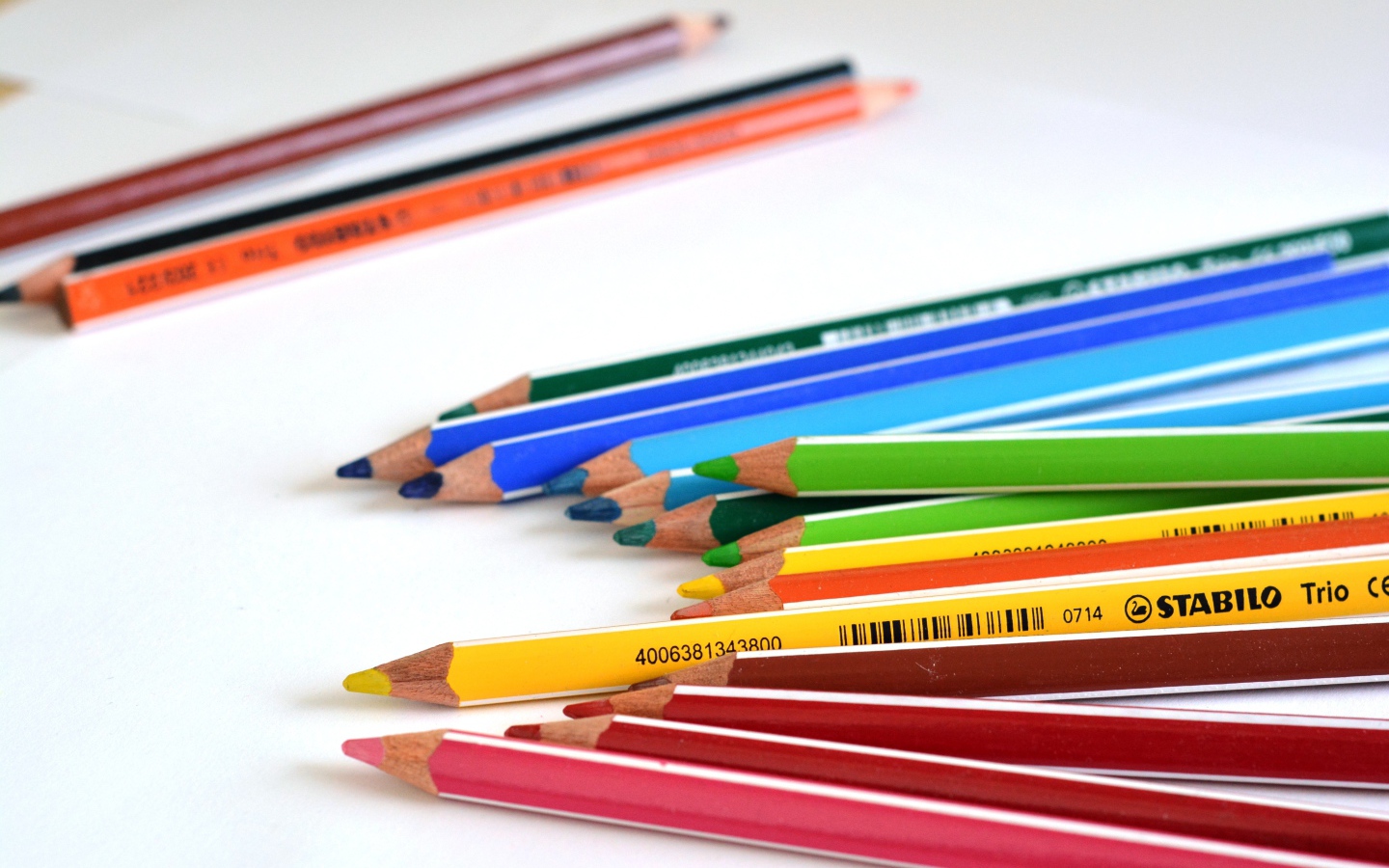 Multi-colored pencils on white table