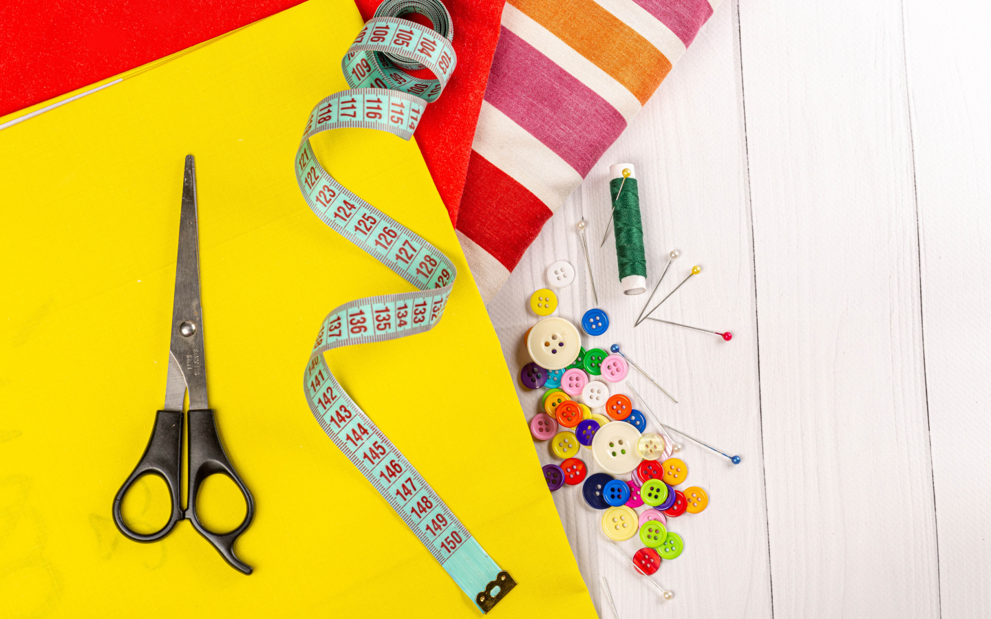 Разноцветная бумага и набор для шитья на столе 