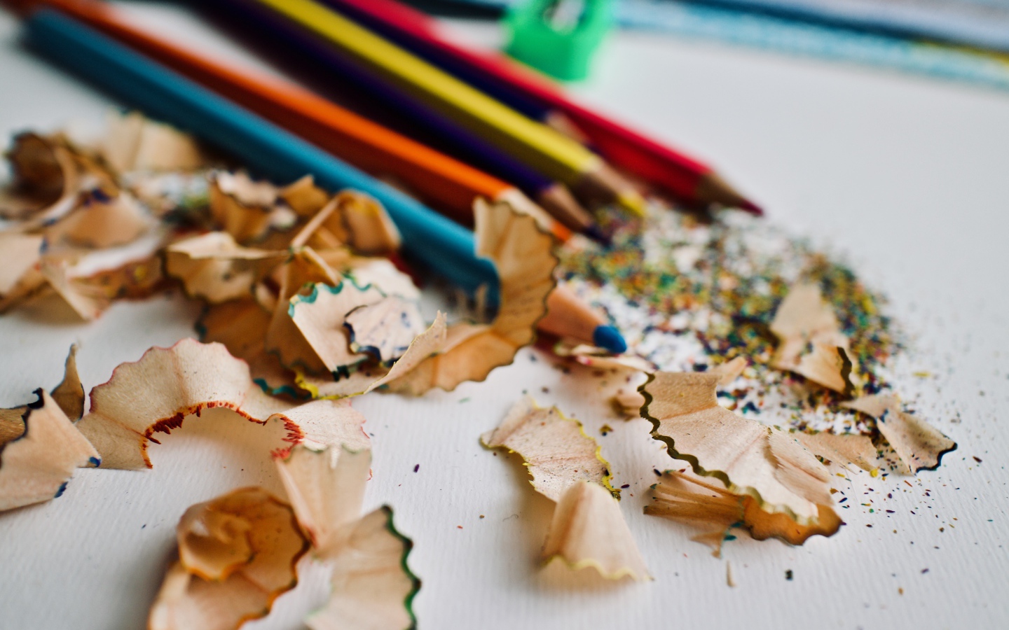 Карандаши со стружкой на сером столе 