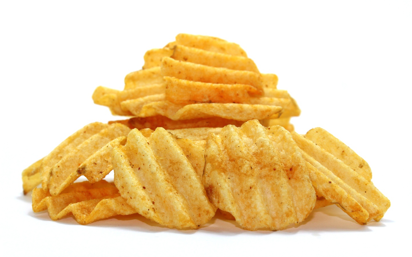 Аппетитные картофельные чипсы на сером фоне