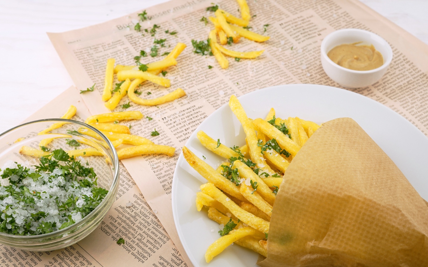 Картофель фри с зеленью на газете