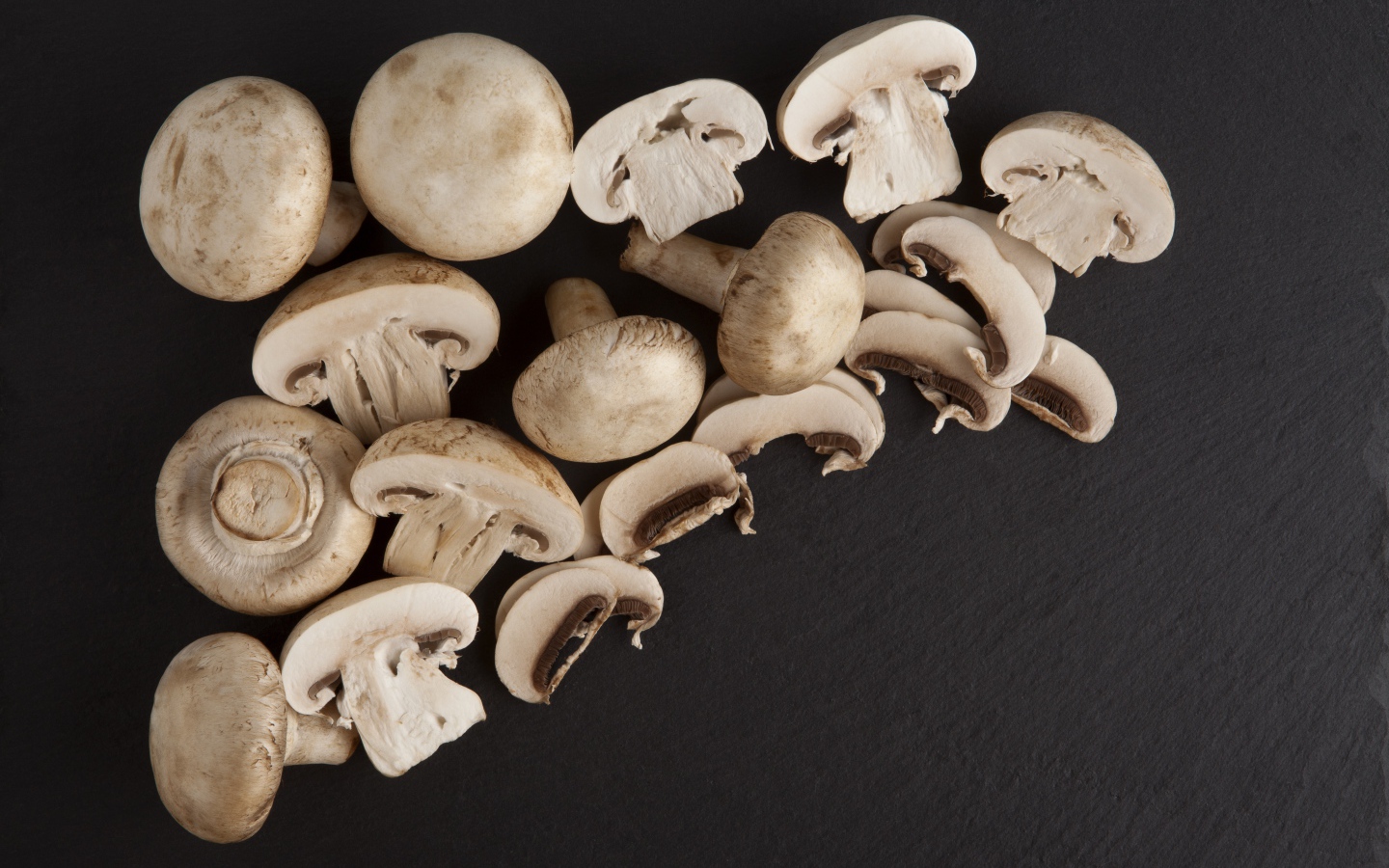 Свежие нарезанные шампиньоны на сером фоне