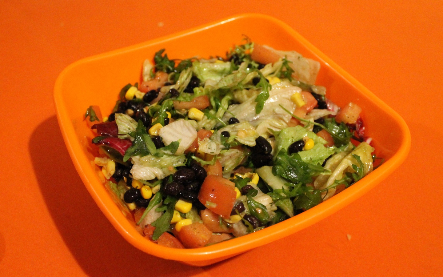 Салат из свежих овощей на оранжевом фоне