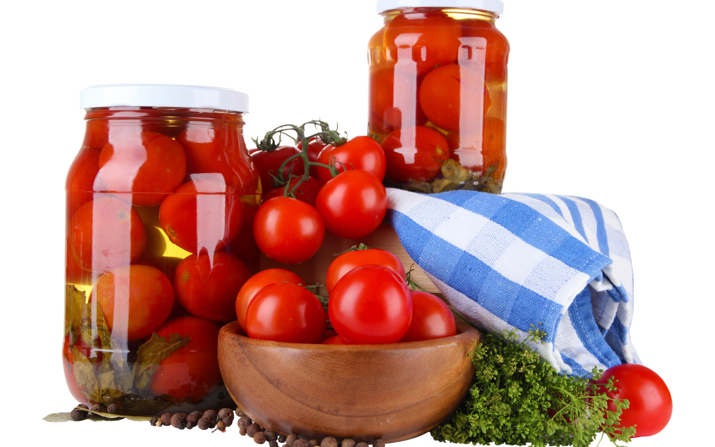 Маринованные помидоры в банках на столе со свежими