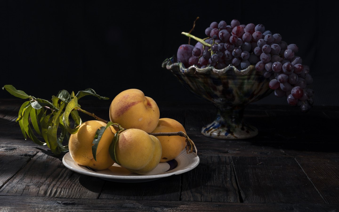 Красивые сочные персики на столе с виноградом