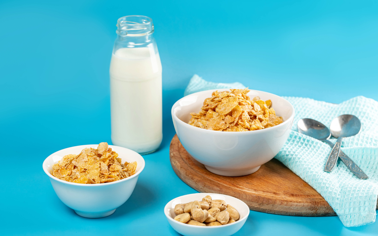 Хлопья на столе с орехами и молоком на голубом фоне