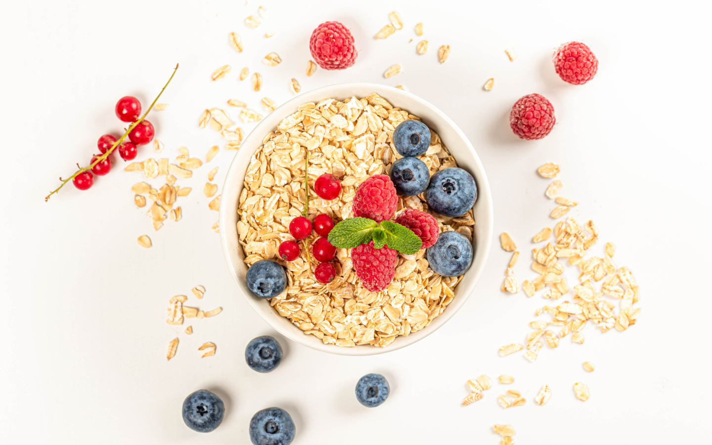 Овсяные хлопья с ягодами черники и малины на белом фоне 