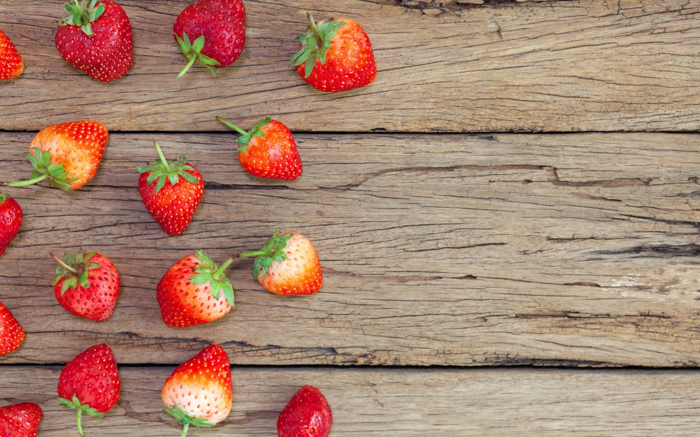 Спелая красная клубника лежит на деревянном столе