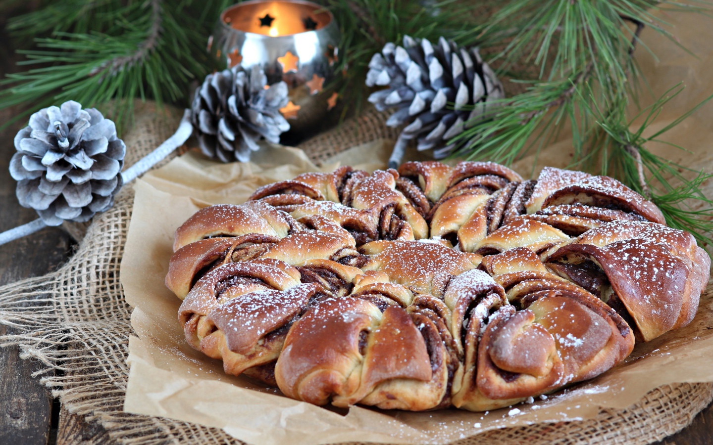 Сдобный венок с вареньем на столе с шишками