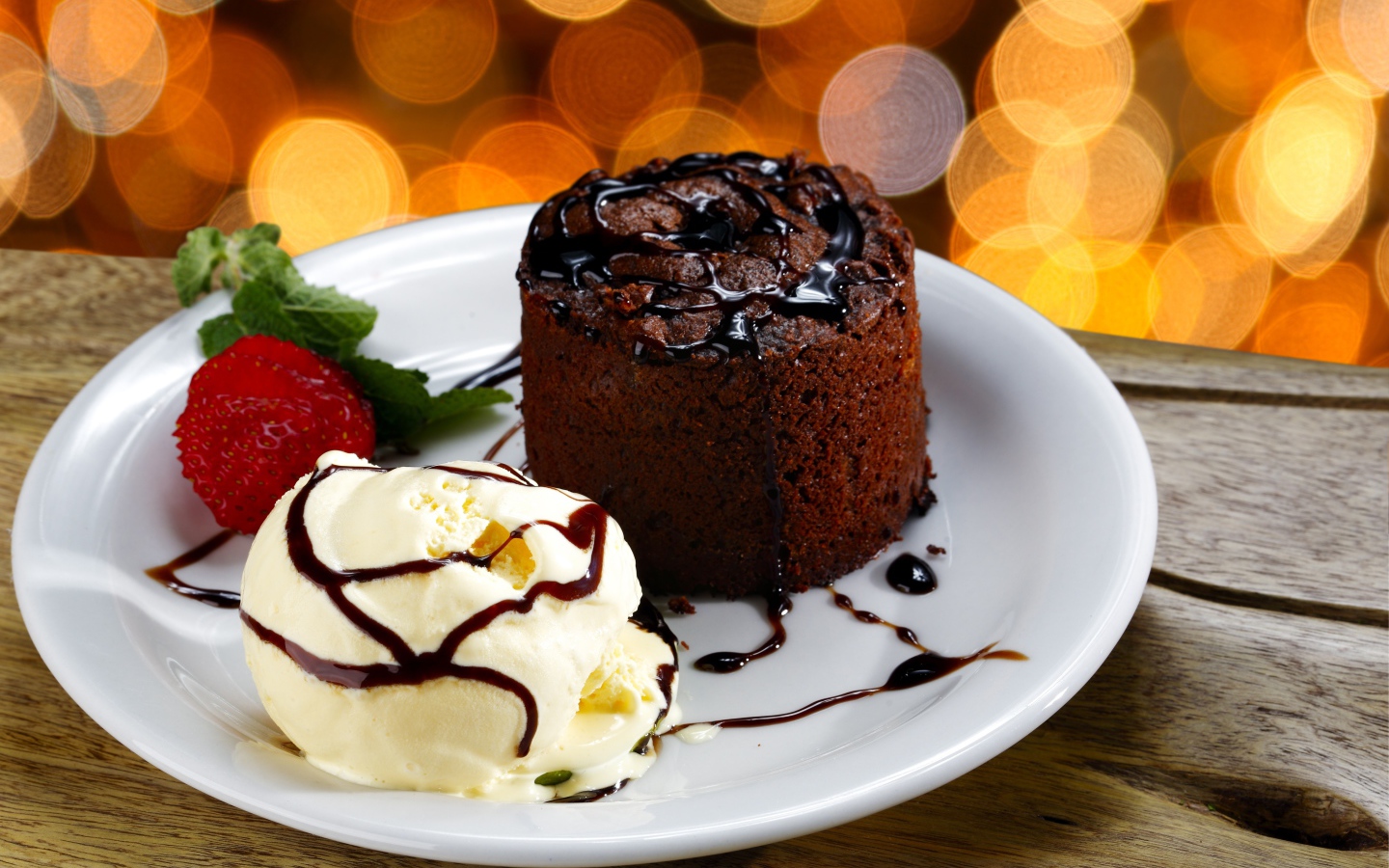 Шоколадный десерт с мороженым и клубникой на белой тарелке 