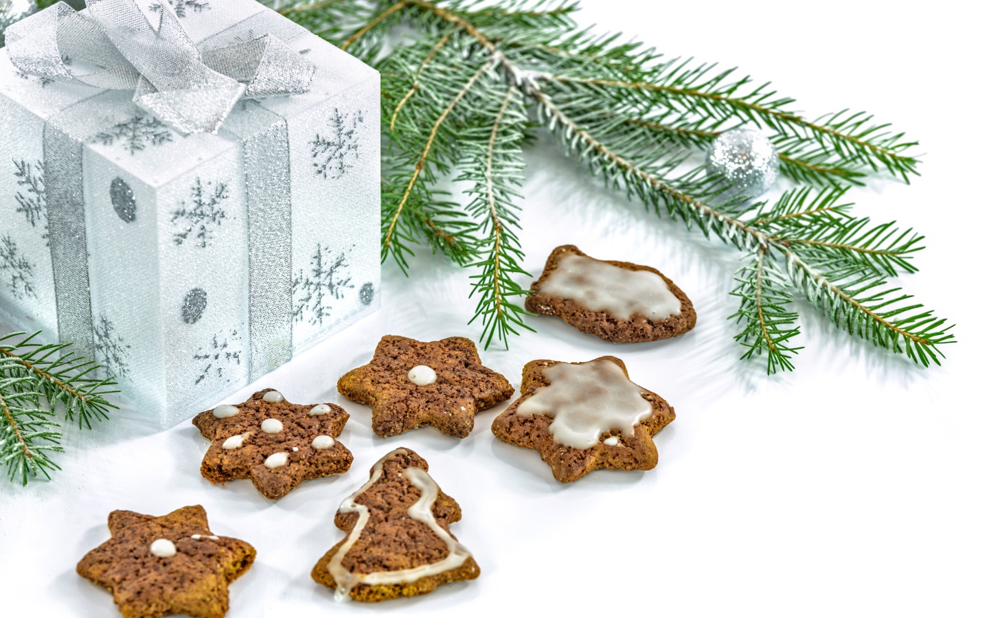 Вкусное печенье с еловой веткой и подарком на белом фоне 