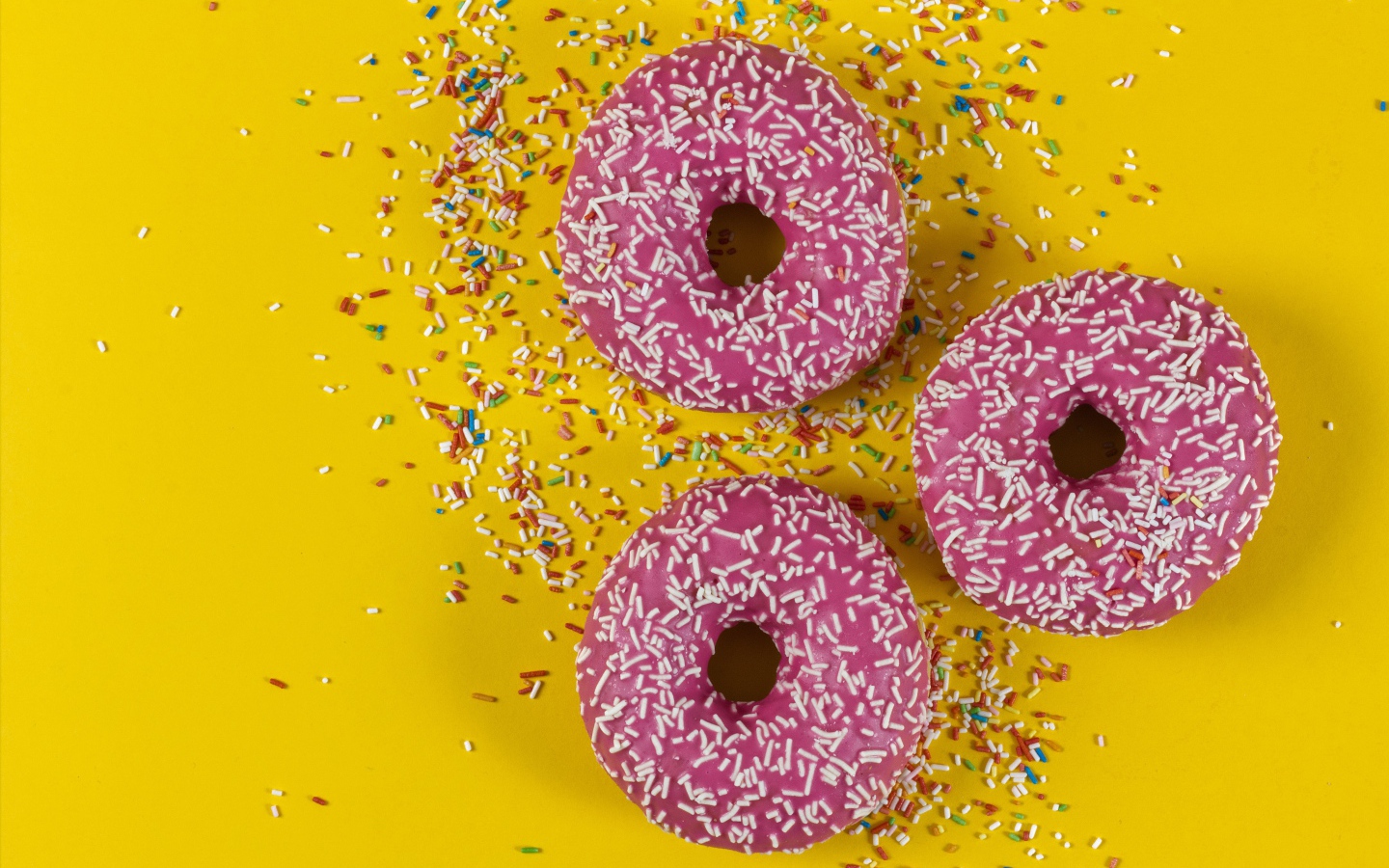 Пончики с розовой глазурью на желтом фоне