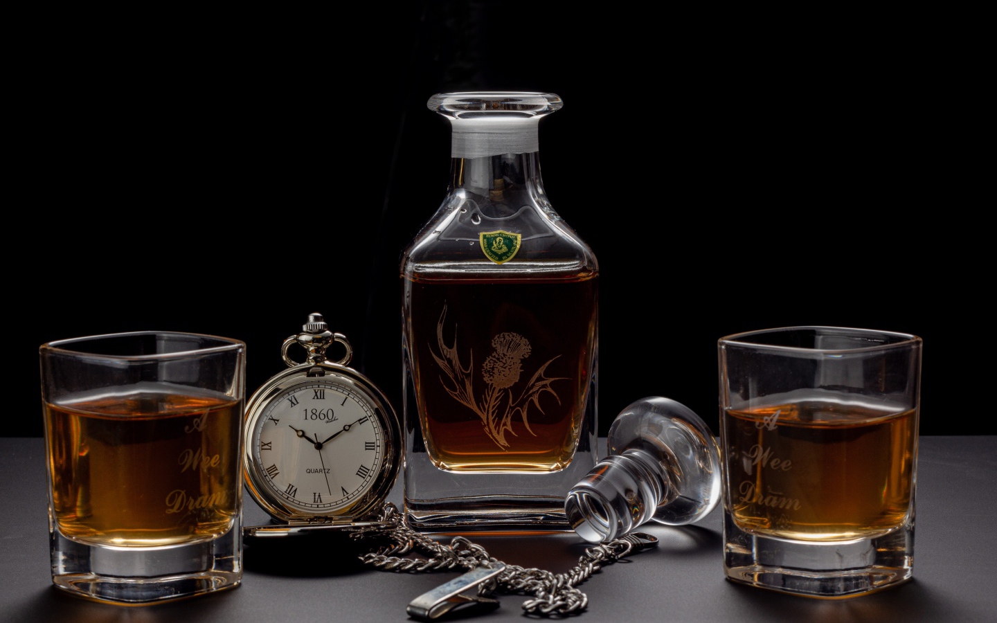 Expensive cognac on the table with a pocket watch