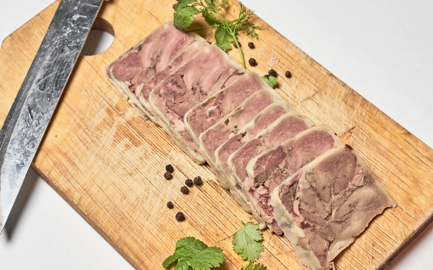 Мясной продукт на деревянной доске с ножом 