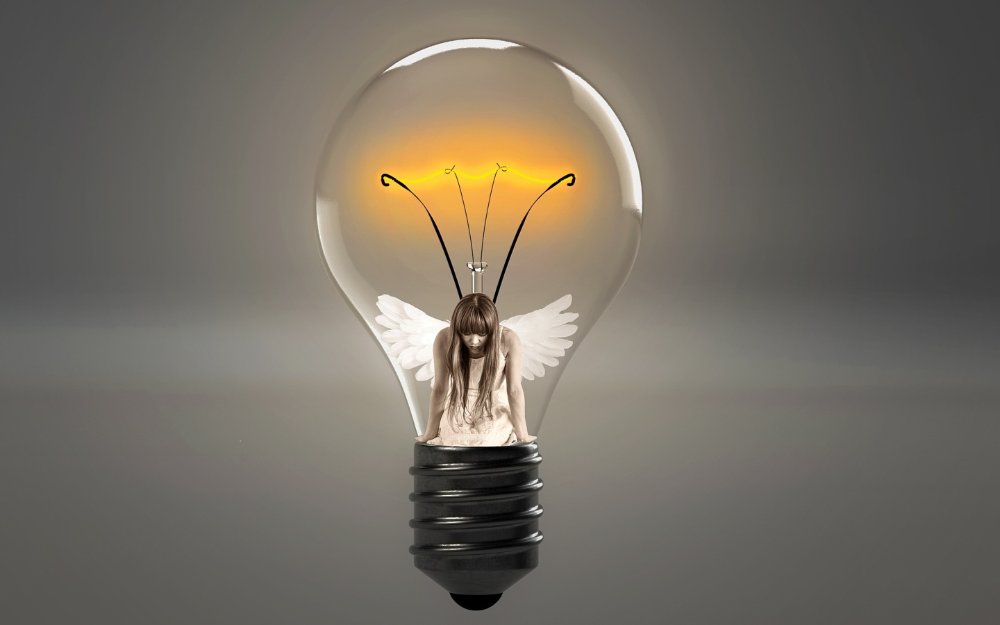 Angel girl in incandescent lamp on gray background