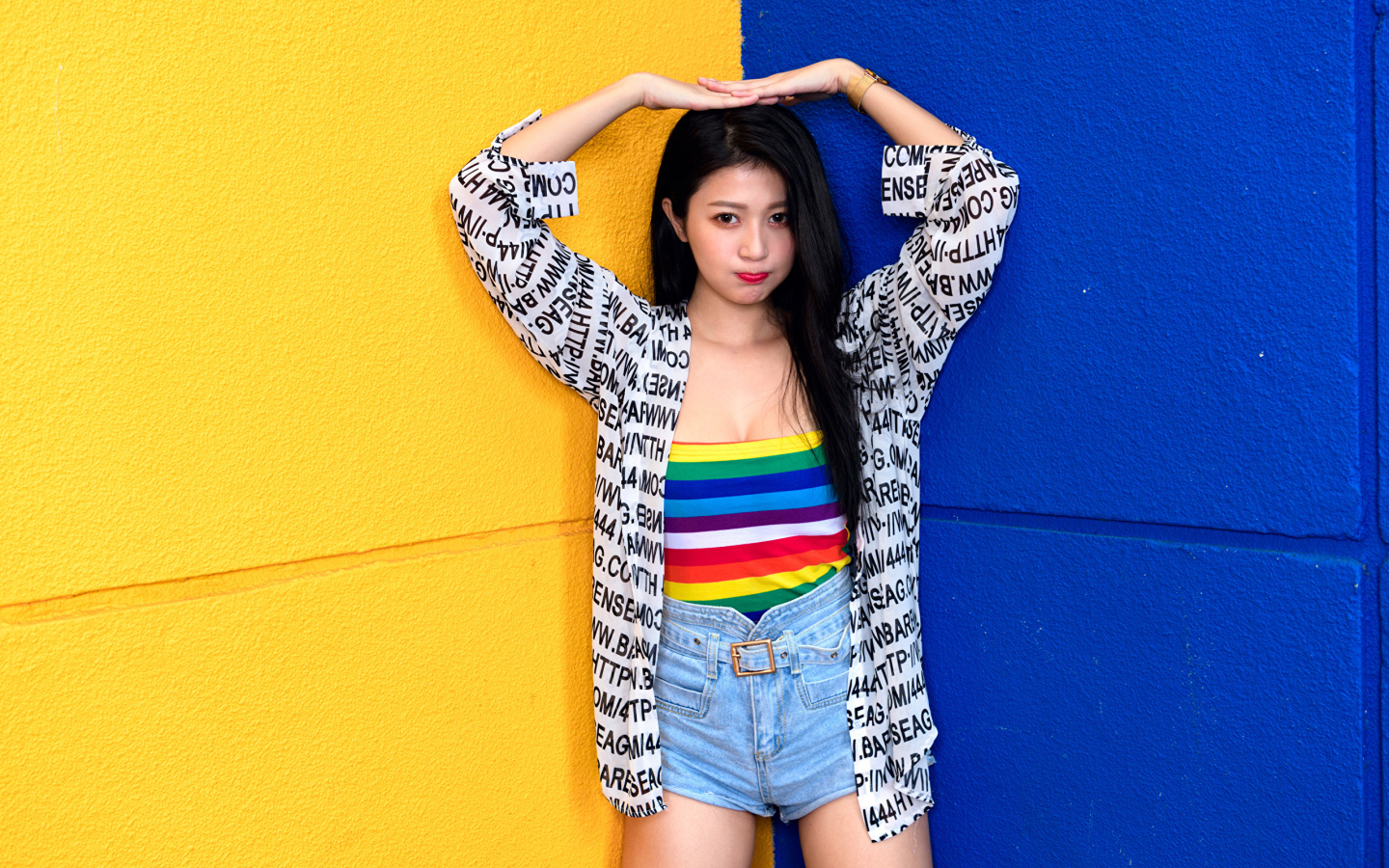 Девушка азиатка стоит у двухцветной стены