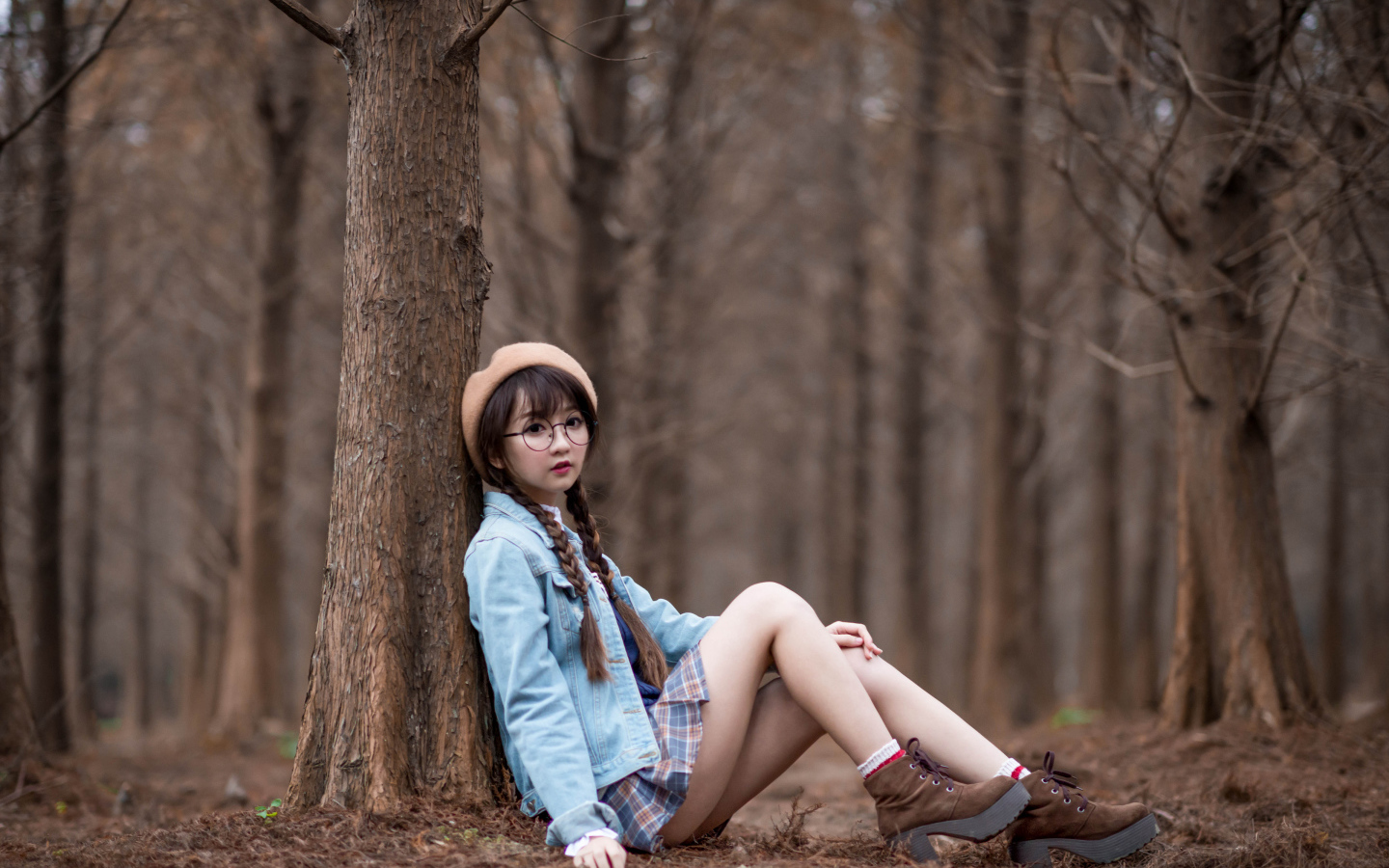 Девушка азиатка школьница сидит под деревом