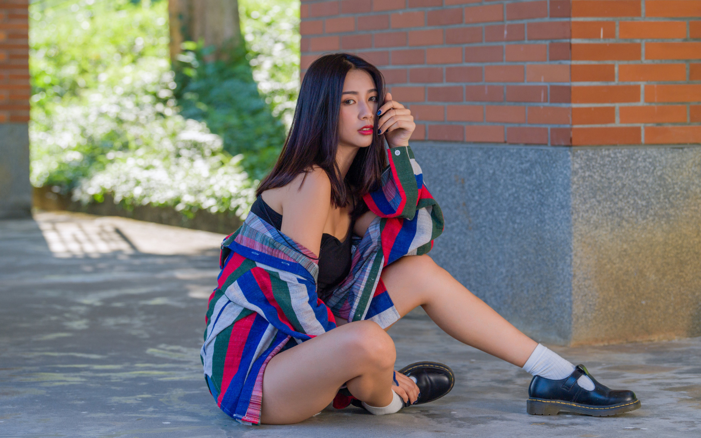 Красивая азиатка в рубашке у стены