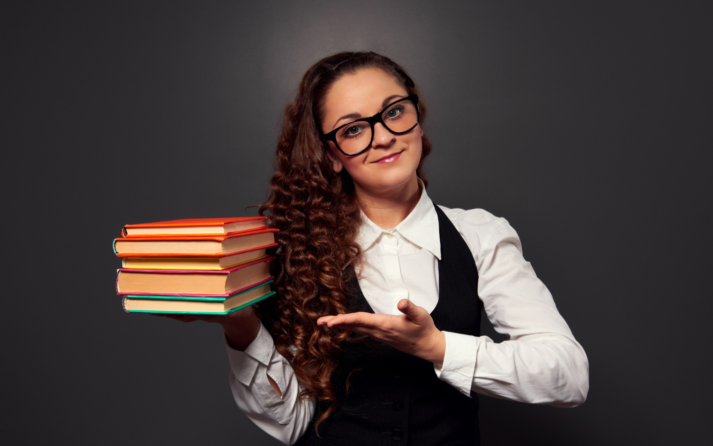 Beautiful girl teacher in glasses with books in hand