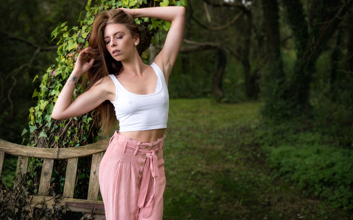 Красивая стройная девушка стоит у дерева 