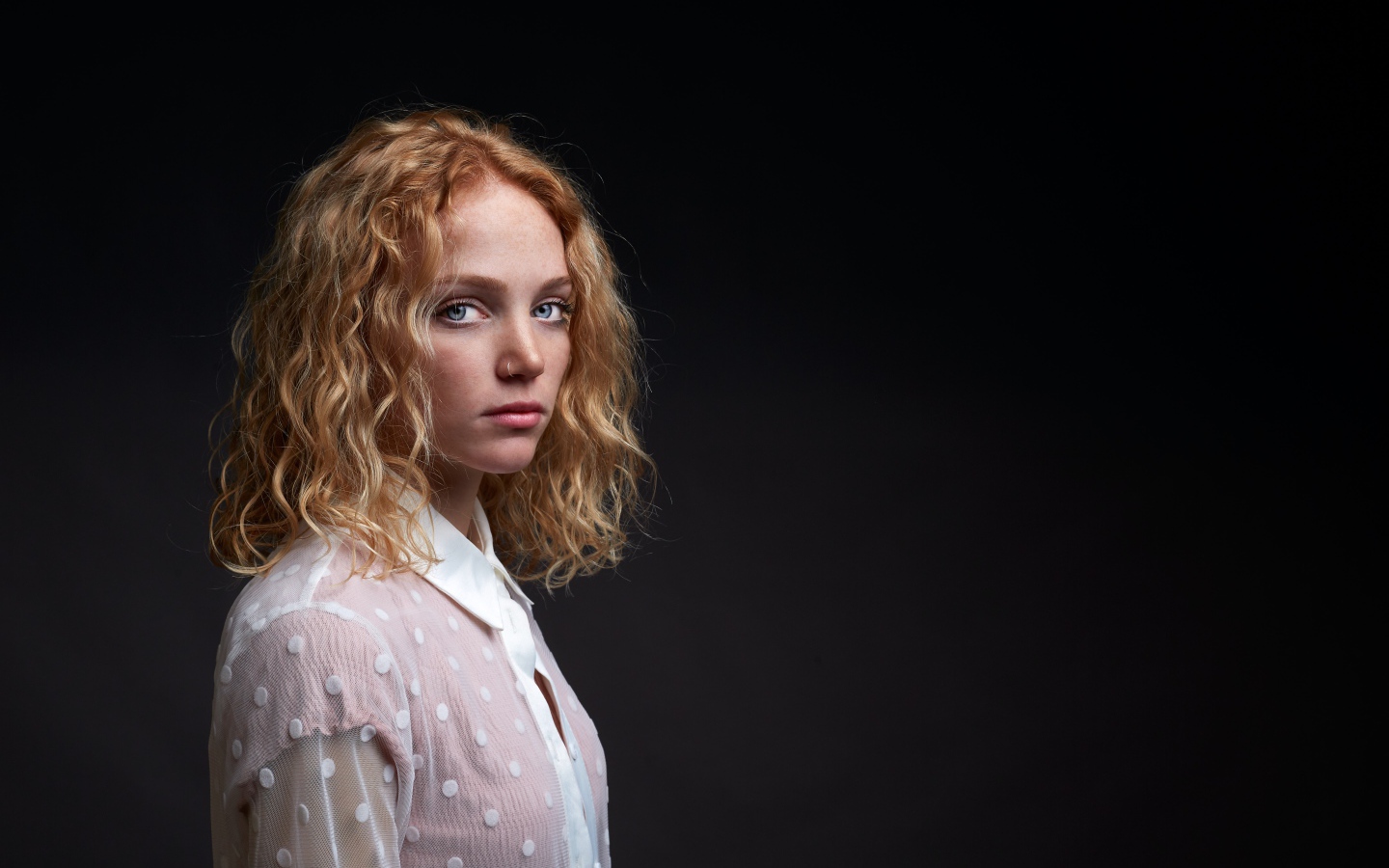 Голубоглазая девушка в белой рубашке на черном фоне
