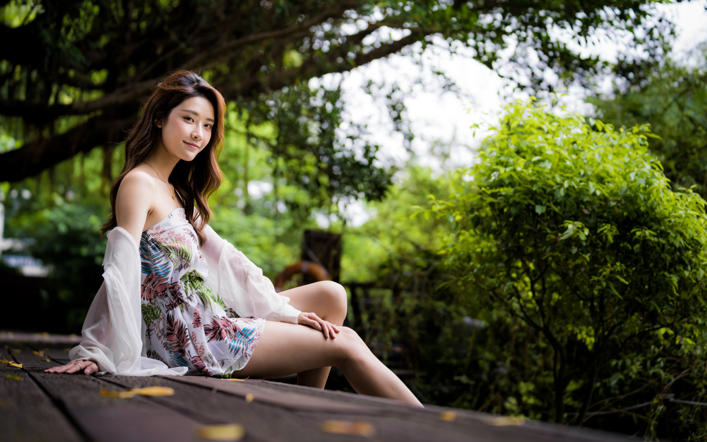 Милая девушка азиатка сидит на мосту