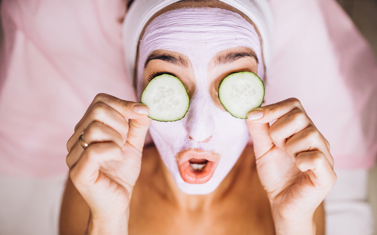 Девушка с маской на лице с огурцами на глазах 