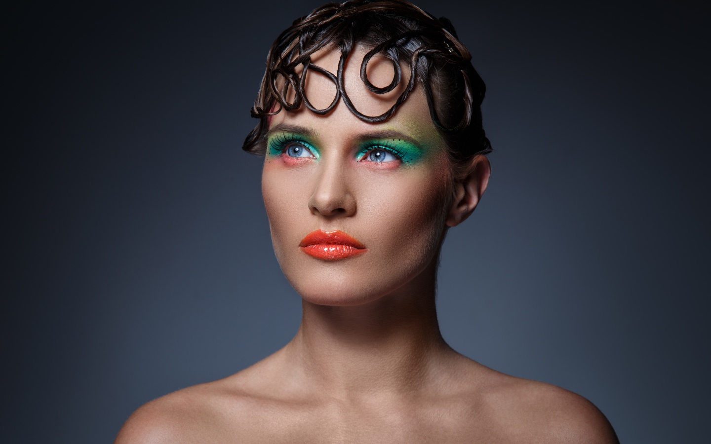 Девушка с ярким макияжем на сером фоне 
