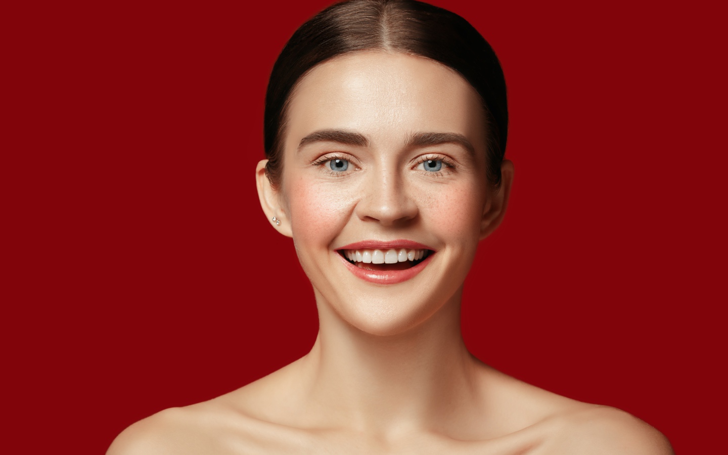 Улыбающаяся молодая девушка на красном фоне