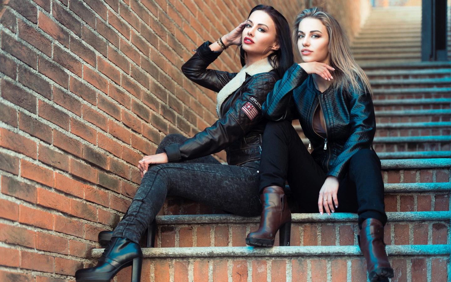 Две красивые девушки сидят на ступенях 