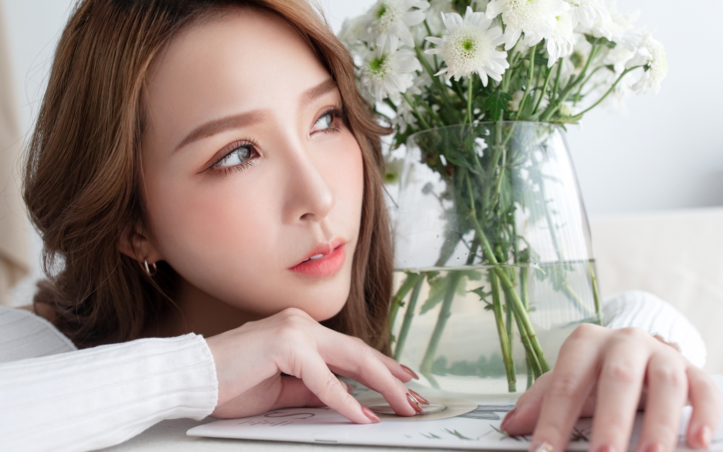 Молодая азиатка с букетом белой хризантемы в вазе