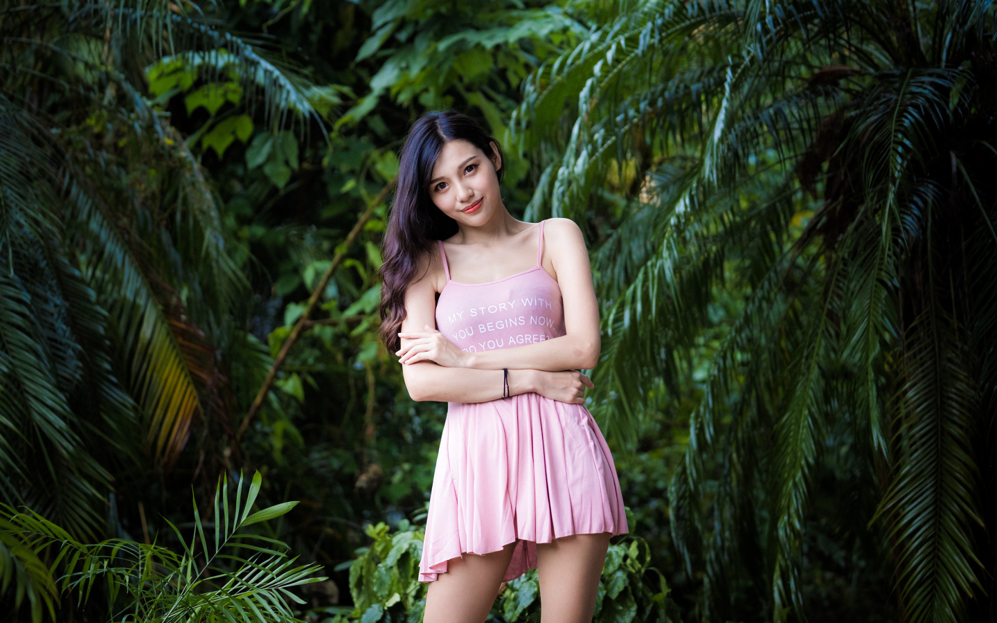 Молодая девушка азиатка на фоне зеленых листьев